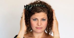 Naomi met haar handen voor haar oren