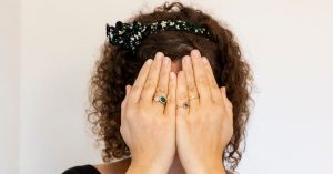 Naomi met haar handen voor haar ogen